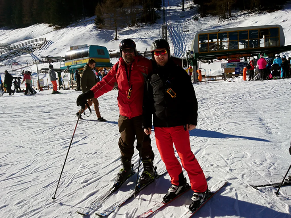 Zwei Personen stehen auf Skiern vor der Bergstation.